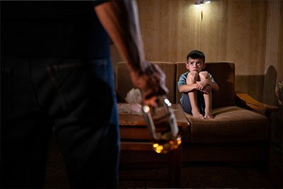 Генетическая алкогольная зависимость Мальчик смотрит на мужчину в алкогольном опьянении