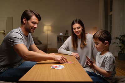 Семейная жизнь Семья из трех человек играет в UNO