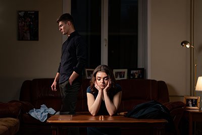 Развод Женщина сидит за столом рядом с ней стоит мужчина