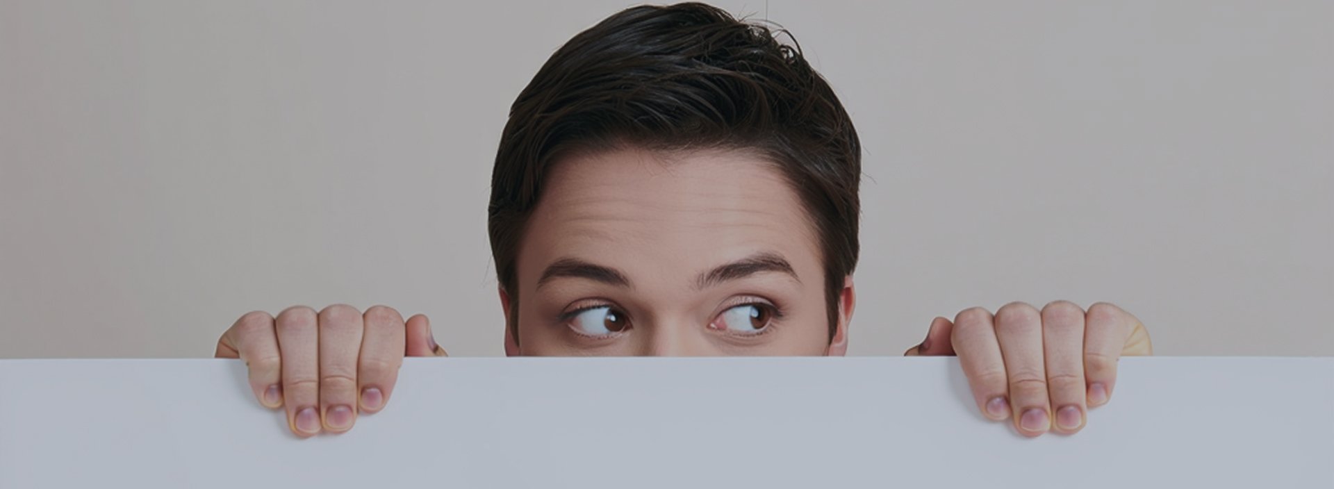 Человек выглядывает со страхом из-под стола